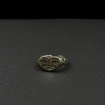 Adjustable silver ring with a heart design and engraved expressive face